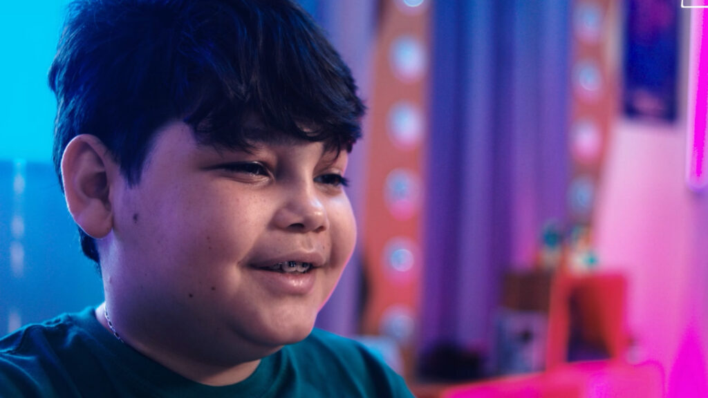 A child speaking in a colorful gaming room in The Hope Level.